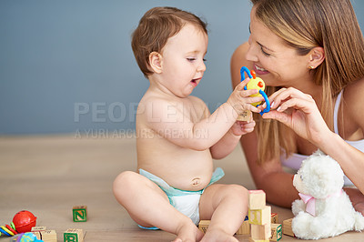 Buy stock photo Shot of an adorable baby girl and her mother playing with wooden blocks at home