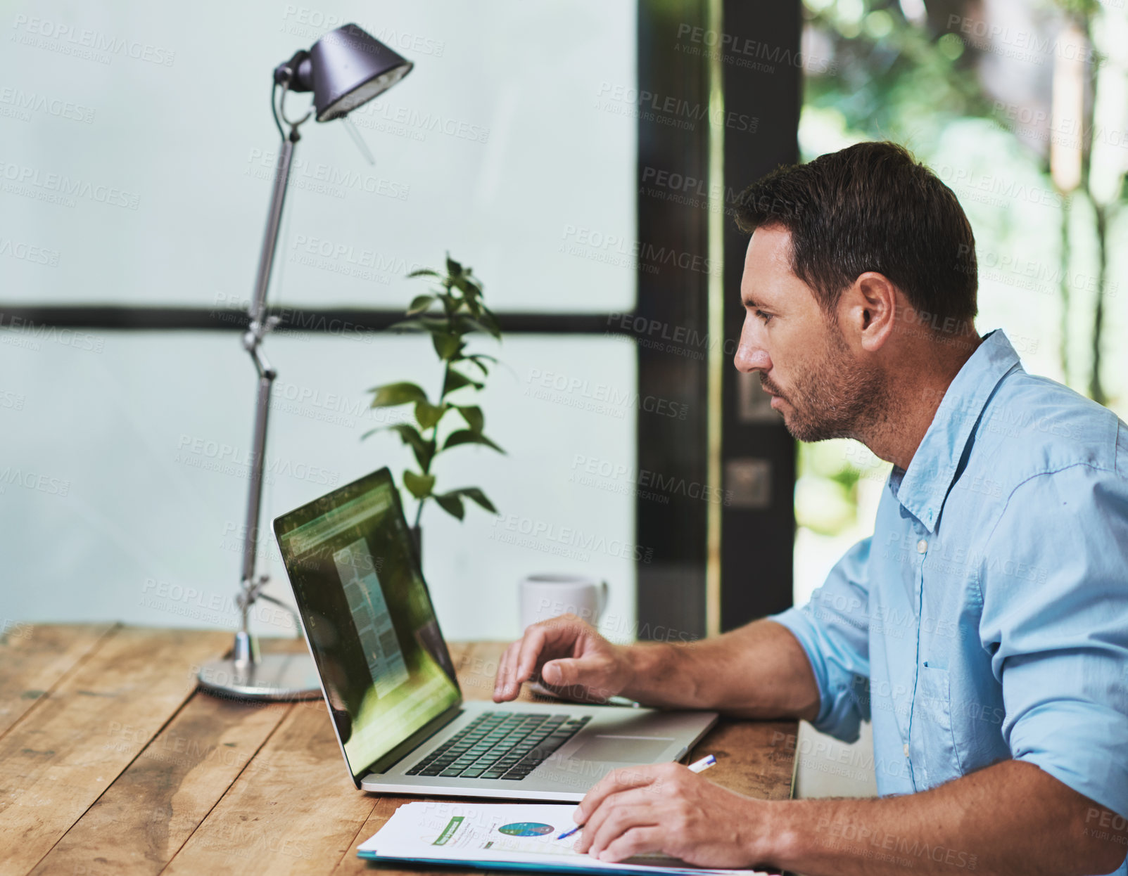 Buy stock photo Cropped shot of a businessman working on his laptop at home