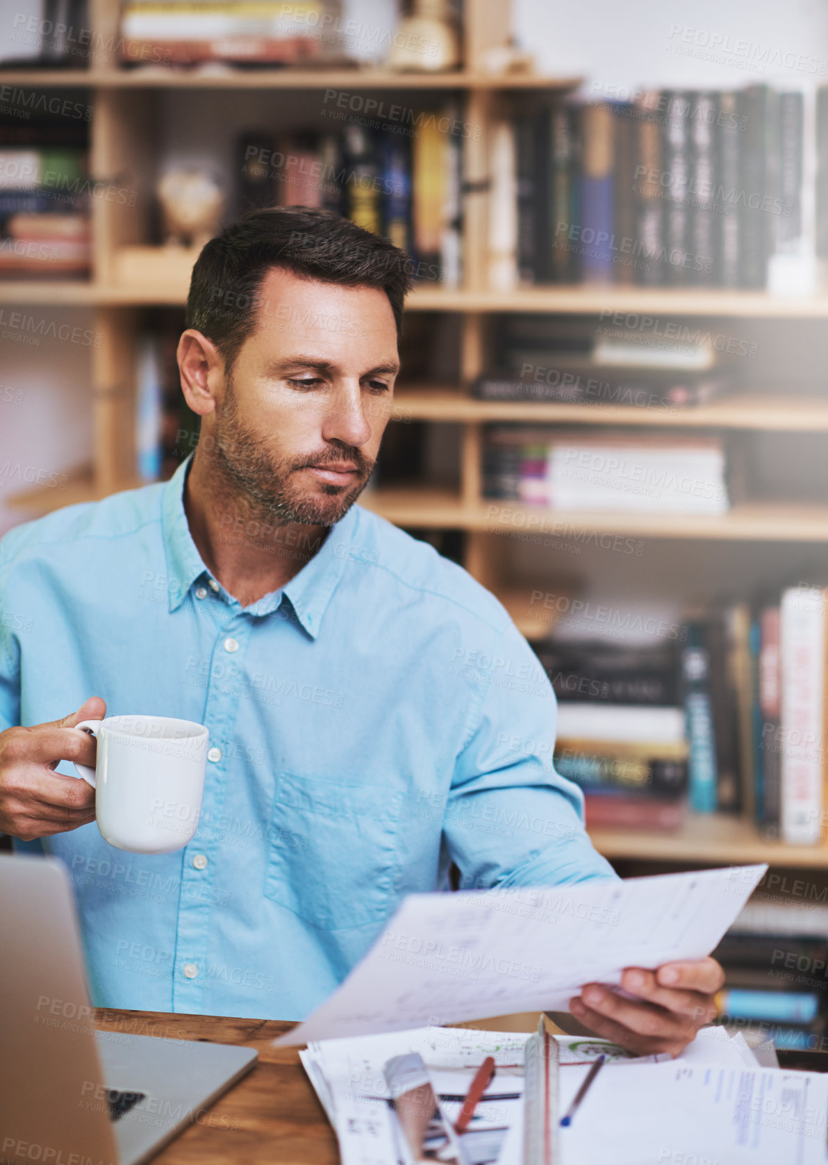 Buy stock photo Cropped shot of a businessman reading some paperwork at home