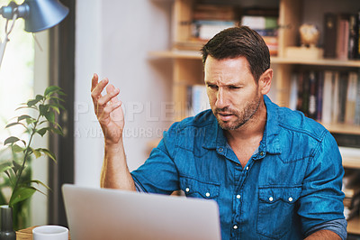 Buy stock photo Cropped shot of a businessman looking a little frustrated while working at home