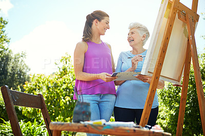 Buy stock photo Shot of a senior woman and her adult daughter painting in a park