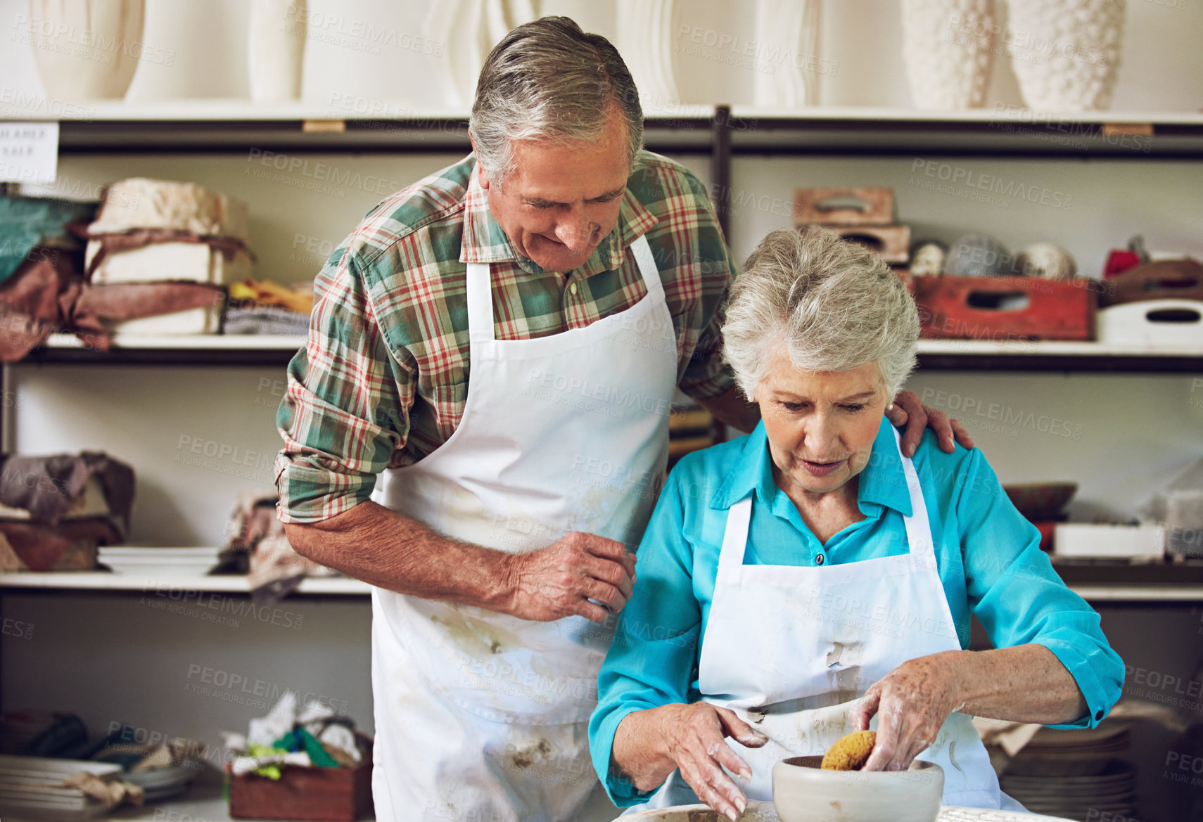 Buy stock photo Shot of a senior couple making a ceramic pot together in a workshop