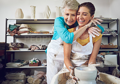 Buy stock photo Shot of a mother and daughter making a ceramic pot together in a workshop