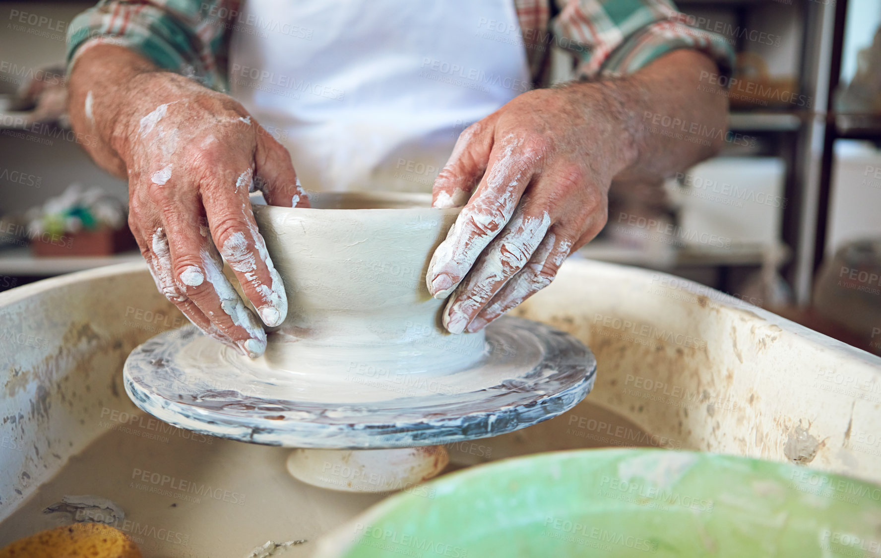 Buy stock photo Cropped shot of a man making a ceramic pot in a workshop