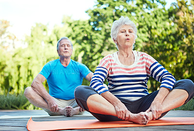 Buy stock photo Shot of a senior couple doing yoga together outdoors