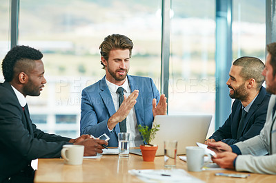 Buy stock photo Shot of a team of colleagues having a meeting around a laptop in a modern office