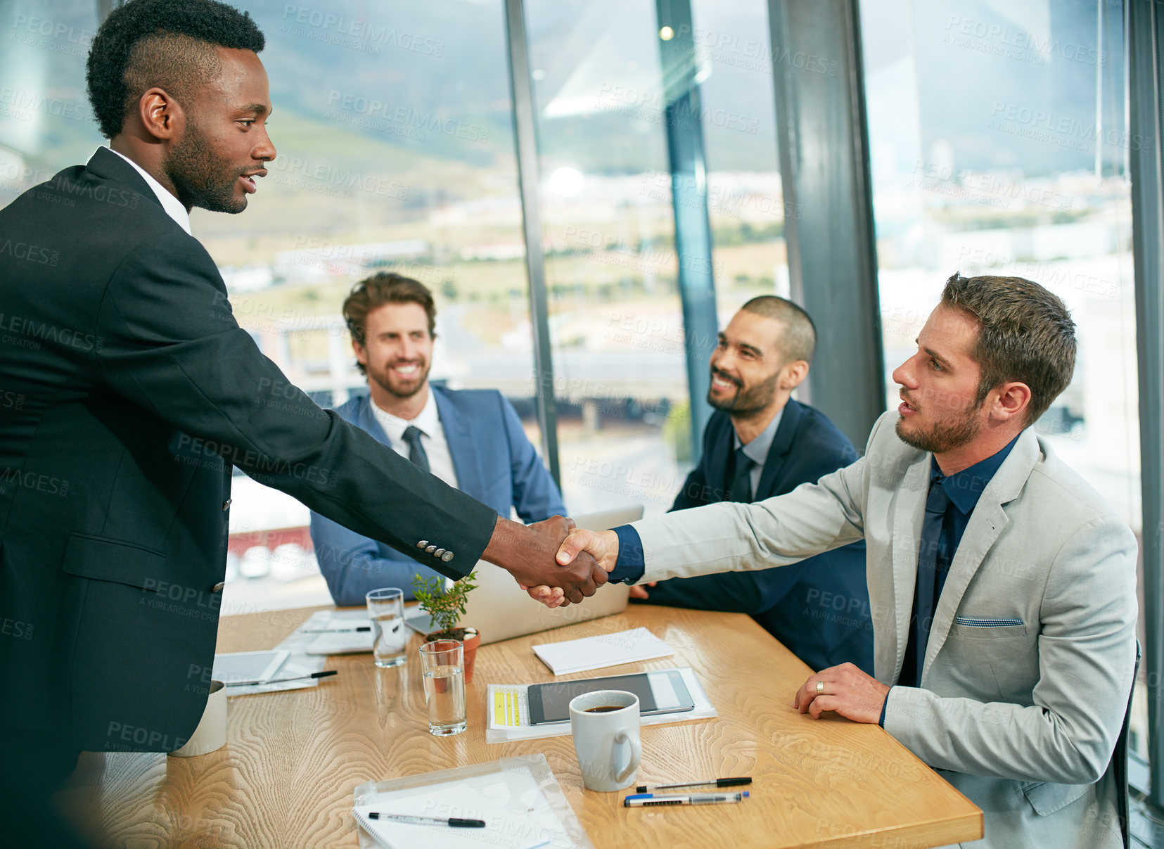 Buy stock photo Shot of businessmen shaking hands during a meeting