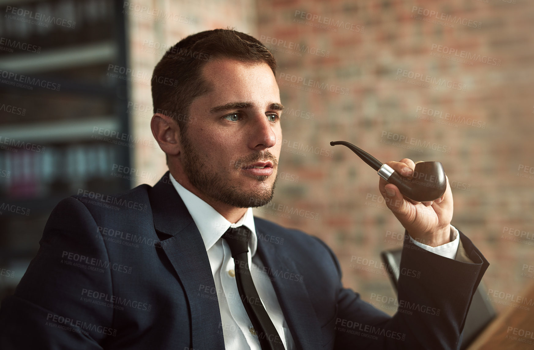 Buy stock photo Shot of a stylish businessman smoking a pipe in the office