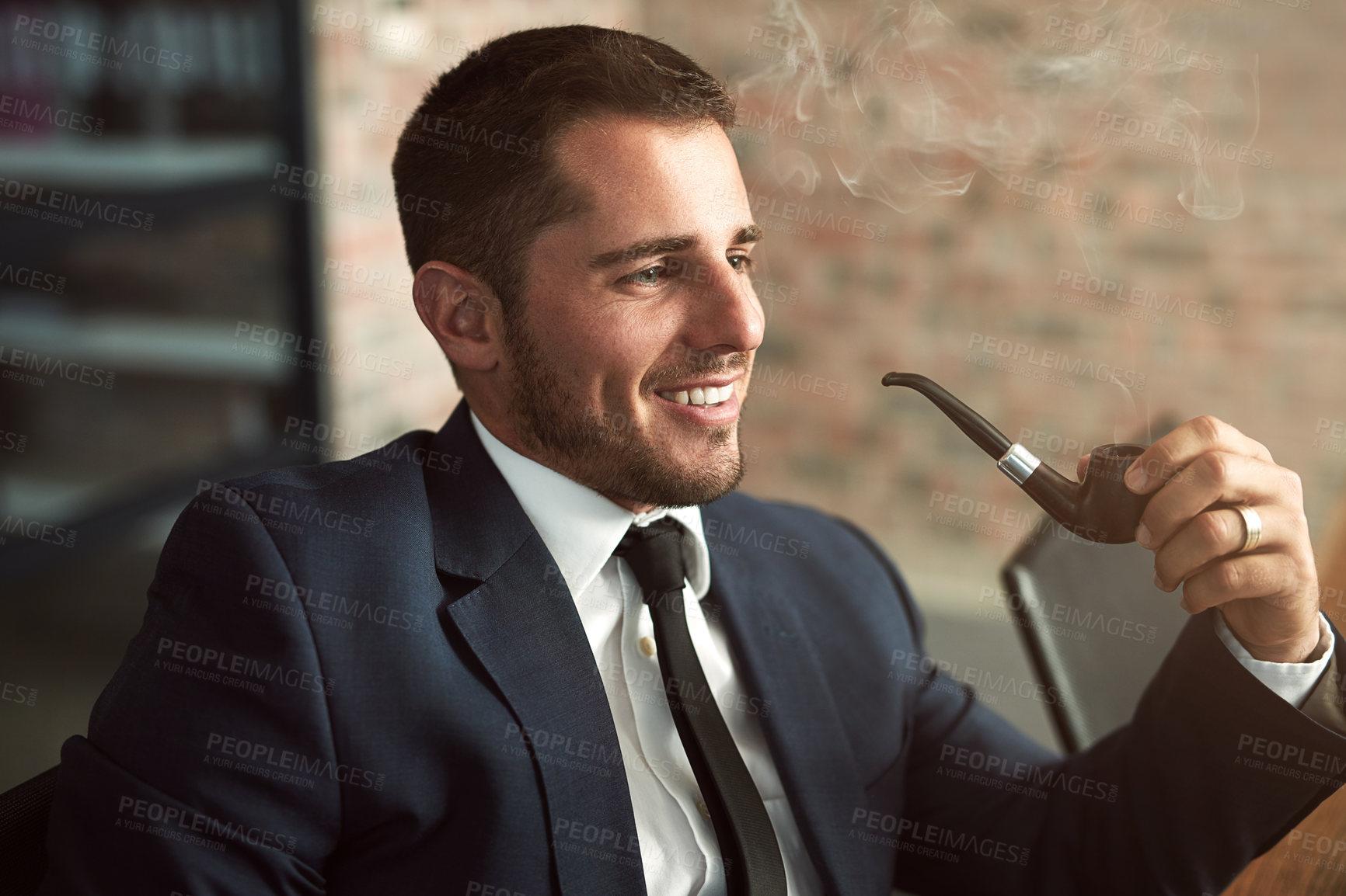 Buy stock photo Shot of a stylish businessman smoking a pipe in the office