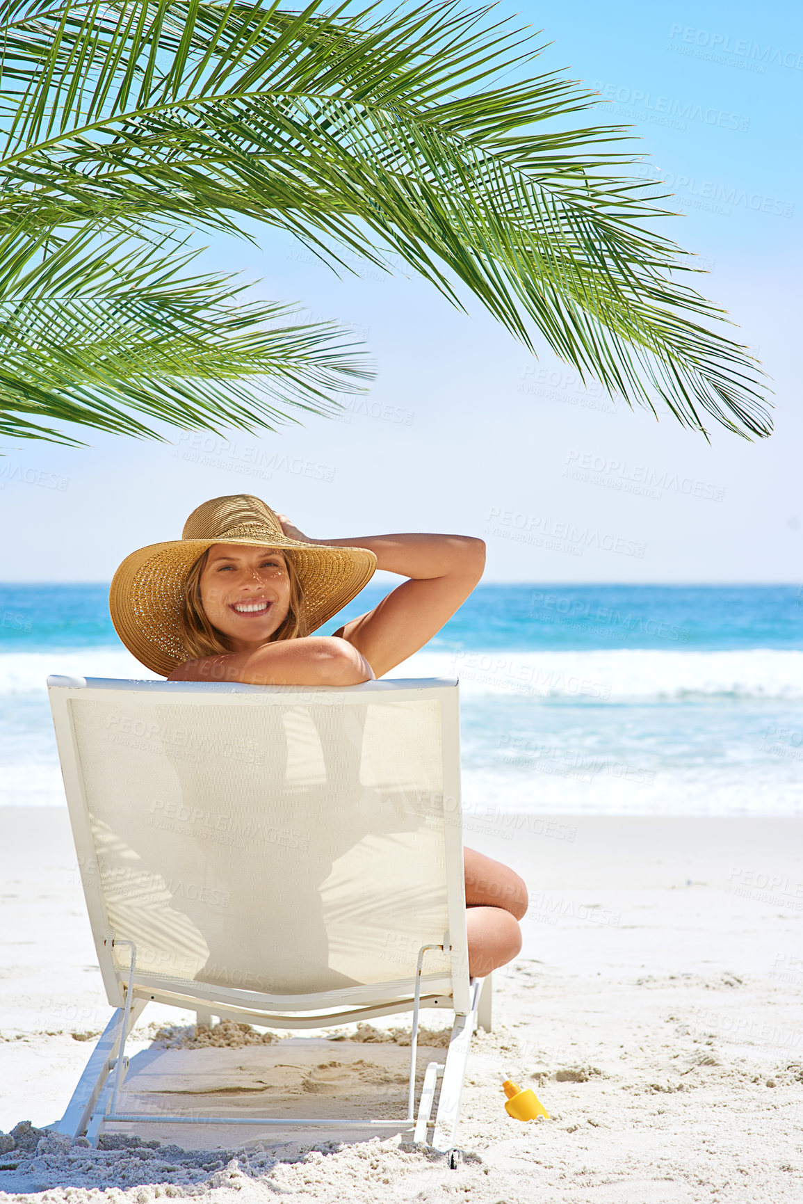 Buy stock photo Rearview portrait of a young woman relaxing at the beach