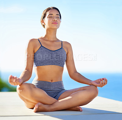 Buy stock photo Cropped shot of a young woman doing yoga outdoors