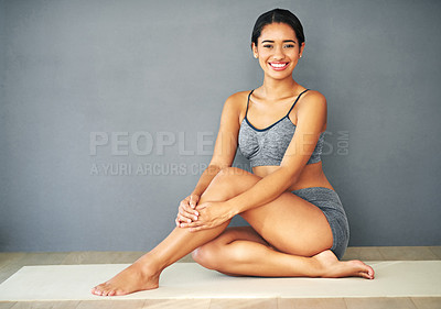 Buy stock photo Shot of a sporty young woman sitting against a grey background