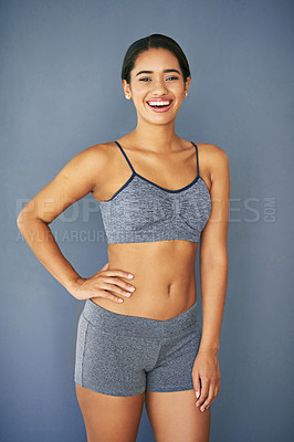 Buy stock photo Shot of a sporty young woman posing against a grey background