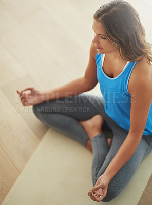 Buy stock photo High angle shot of a young woman practicing the art of meditation at home