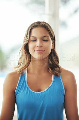 Buy stock photo Cropped shot of a young woman practicing the art of meditation at home
