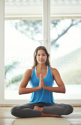 Buy stock photo Full length shot of a young woman practicing the art of meditation at home