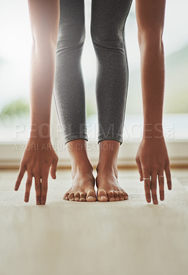Buy stock photo Cropped shot of a young woman practicing yoga at home