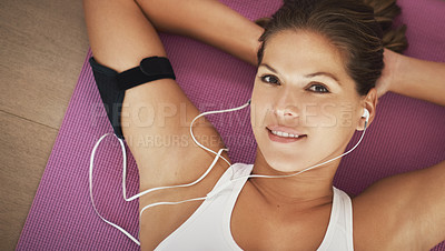 Buy stock photo High angle portrait of a young woman lying with her hands behind her head on a yoga mat