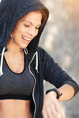 Buy stock photo Cropped shot of an attractive young athlete checking her watch after an outdoor workout