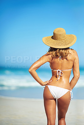 Buy stock photo Rearview shot of a gorgeous young woman in a bikini at the beach