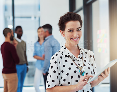 Buy stock photo Cropped portrait of a businesswoman working in the office with her colleagues in the background