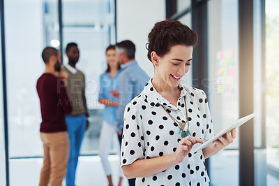 Buy stock photo Cropped shot of a businesswoman working in the office with her colleagues in the background