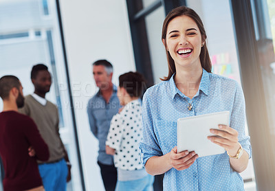Buy stock photo Cropped portrait of a young businesswoman working in the office with her colleagues in the background