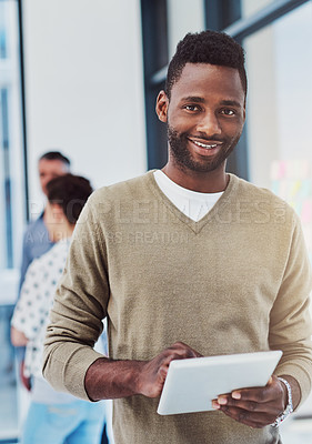 Buy stock photo Cropped portrait of a young businessman working in the office with her colleagues in the background