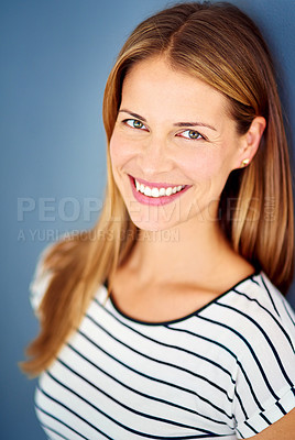 Buy stock photo Cropped shot of a young woman posing against a blue background