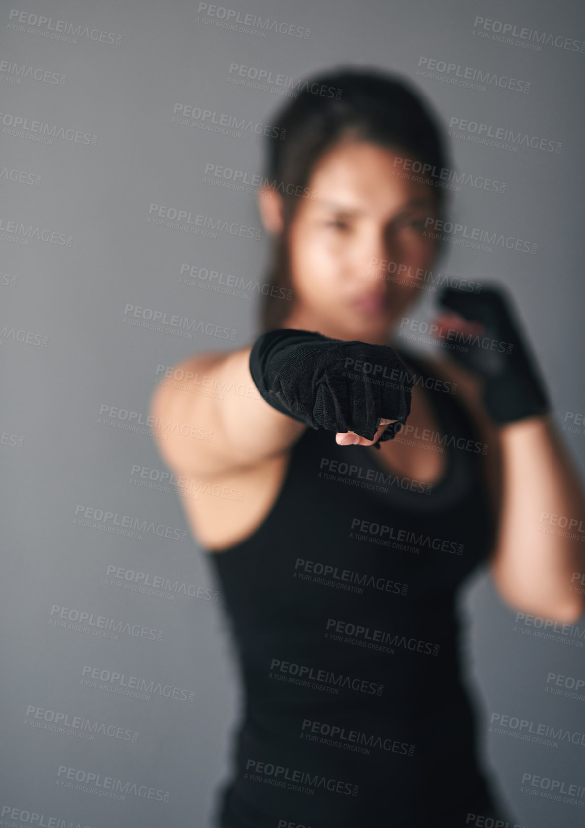 Buy stock photo Woman, hand and fist in studio for training, cardio boxing and ready for fight tournament with power. Girl, strong and gray background for self defense with closeup, combat workout and endurance.