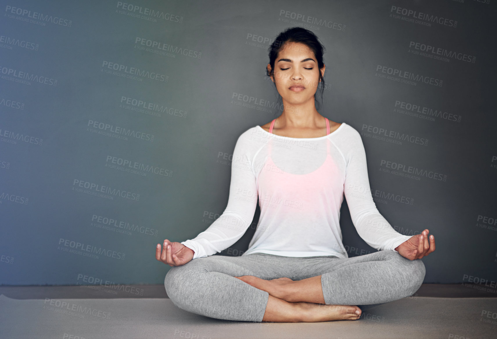 Buy stock photo Shot of an attractive young woman meditating