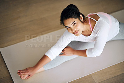 Buy stock photo Portrait of an attractive young woman stretching during her yoga routine