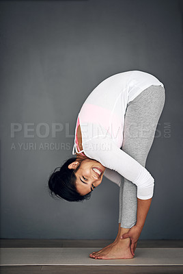 Buy stock photo Shot of a young woman stretching during her yoga routine