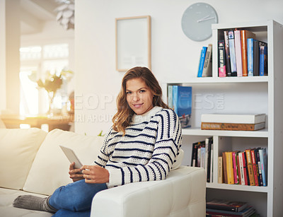 Buy stock photo Portrait of a young woman using her digital tablet on the sofa at home