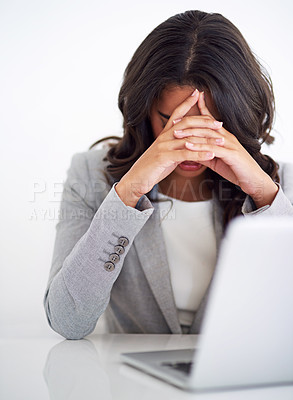 Buy stock photo Cropped shot of a young businesswoman looking stressed while working on her laptop