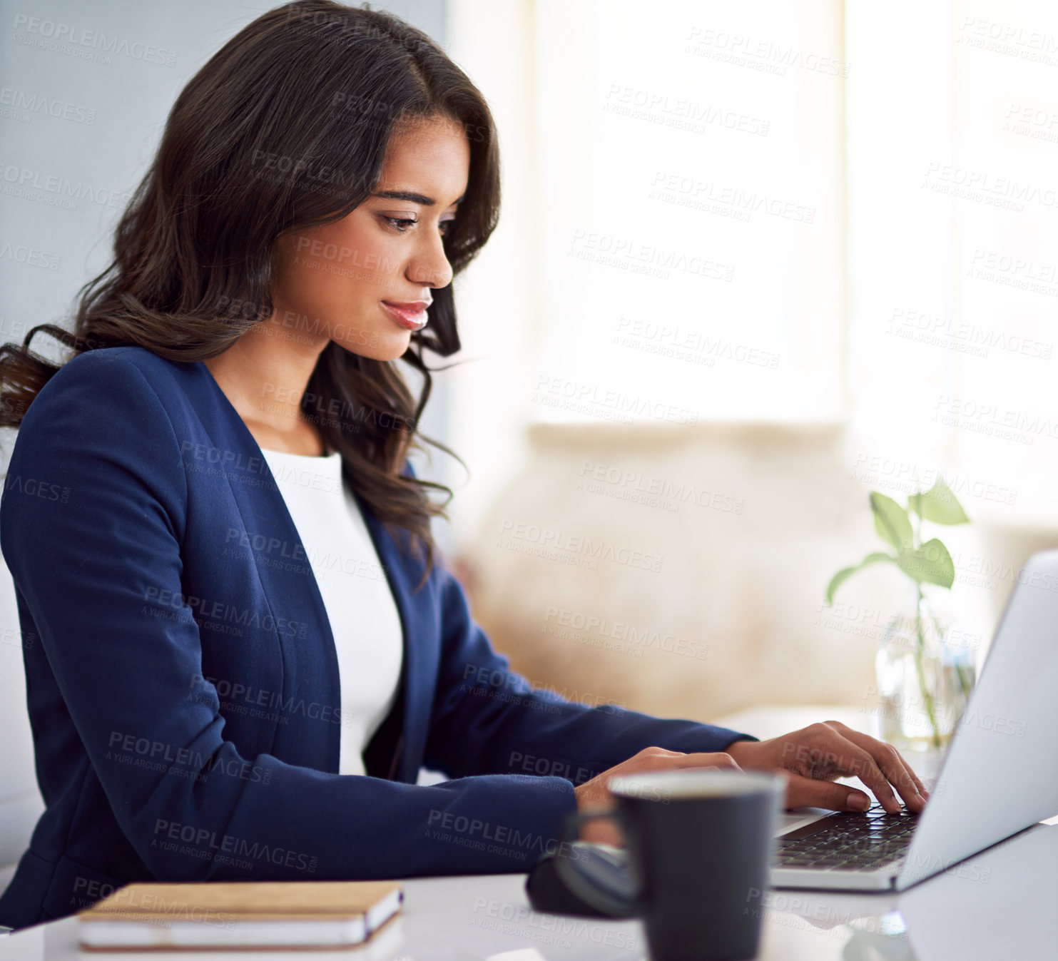 Buy stock photo Cropped shot of a young businesswoman working on her laptop