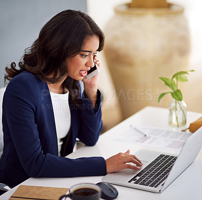 Buy stock photo Cropped shot of a young businesswoman using her cellphone while working on her laptop