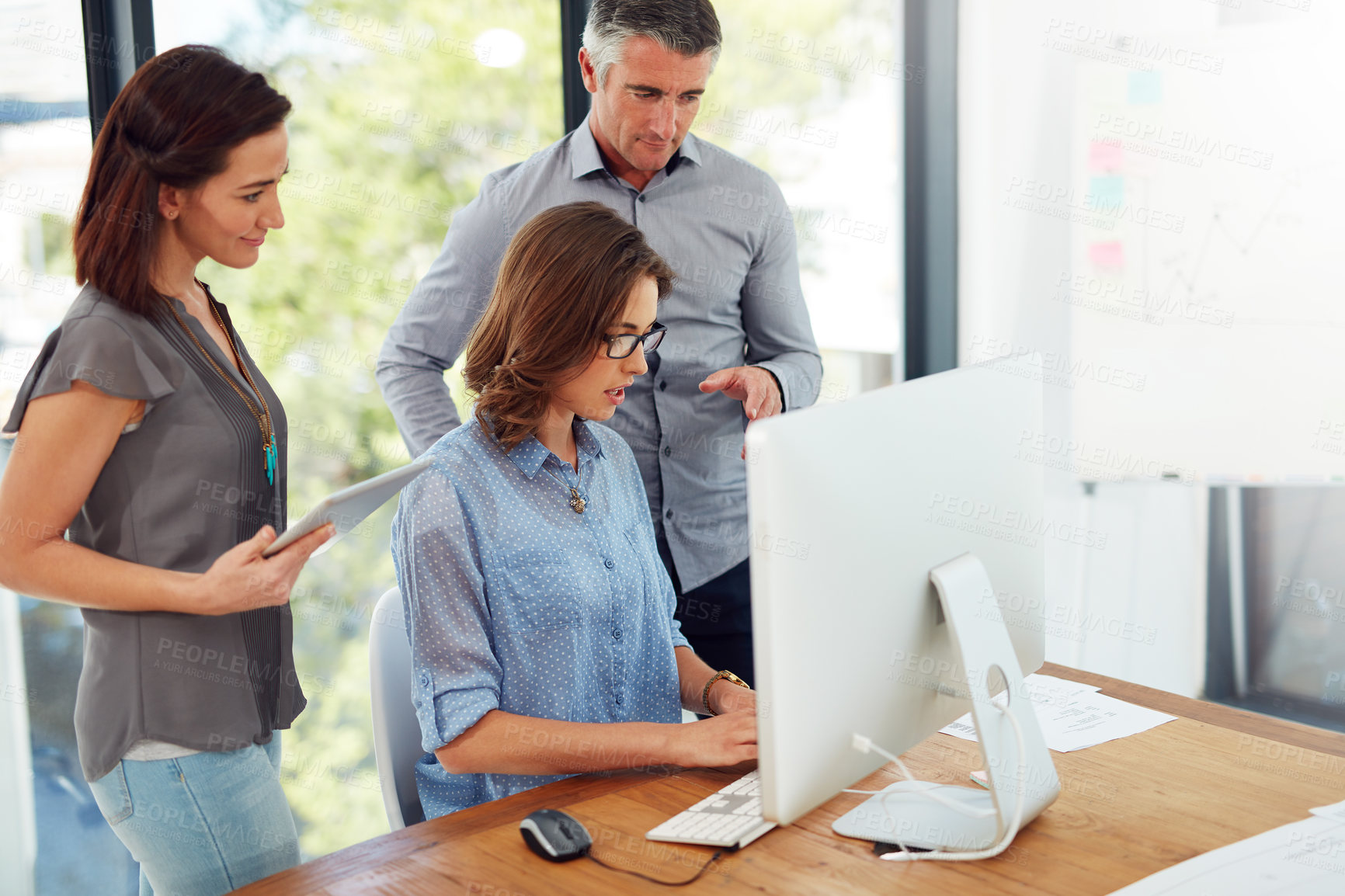 Buy stock photo Shot of group of colleagues using a computer together in an office