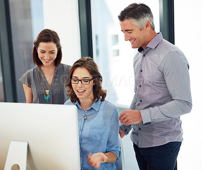 Buy stock photo Shot of group of colleagues using a computer together in an office