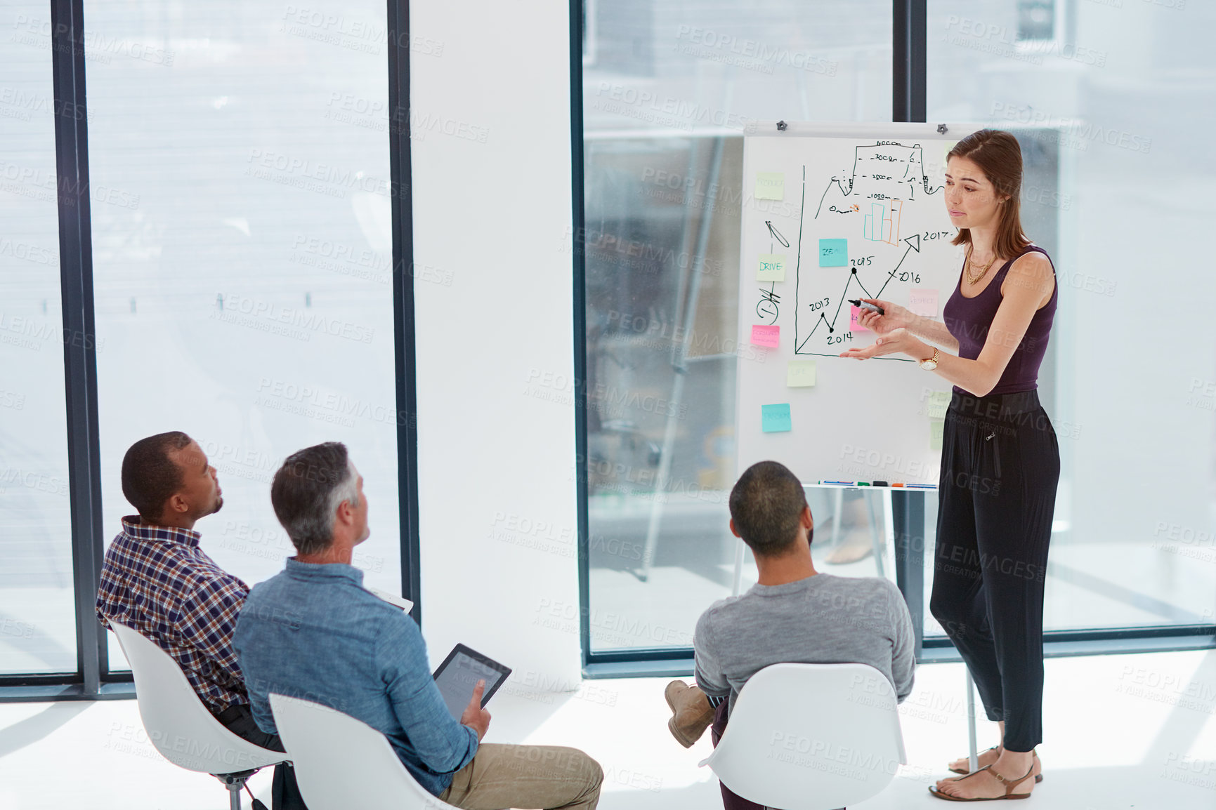 Buy stock photo Shot of a young businesswoman giving a presentation in the boardroom