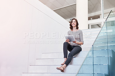 Buy stock photo Portrait of a young businesswoman using a digital tablet on the stairs in a modern office