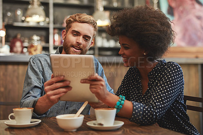 Buy stock photo Couple, tablet and reading on date in cafe with social media streaming, bonding and online information. Interracial, people and smile in coffee shop with tech app for post update, watching and relax
