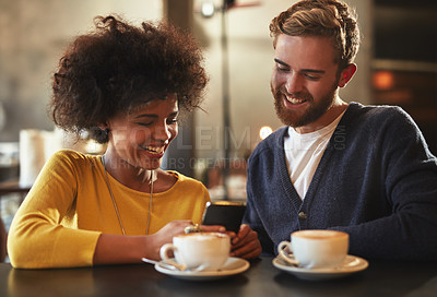 Buy stock photo Shot of a young couple using a mobile phone together on a coffee date