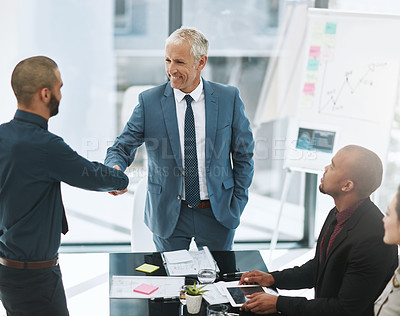 Buy stock photo Shot of two businessmen shaking hands during a meeting in the boardroom