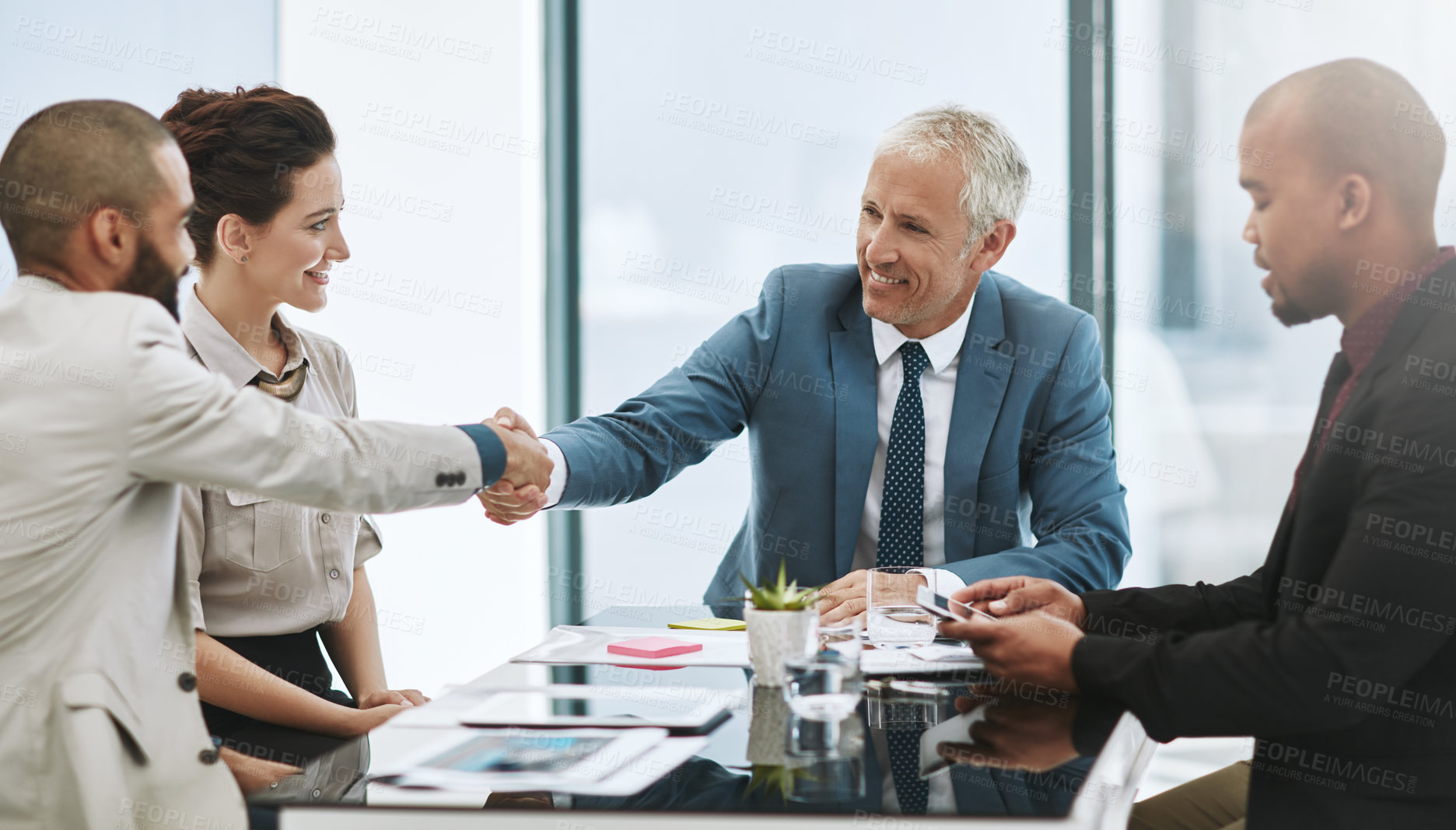 Buy stock photo Shot of two businessmen shaking hands during a meeting in the boardroom