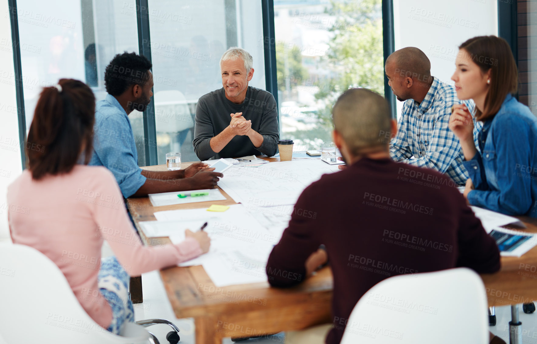 Buy stock photo Businessman, coach and discussion with team in meeting for collaboration, creative planning or brainstorming at office. Man talking to group of employees in boardroom and idea in startup at workplace