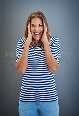 Buy stock photo Studio shot of a young woman looking excited against a gray background