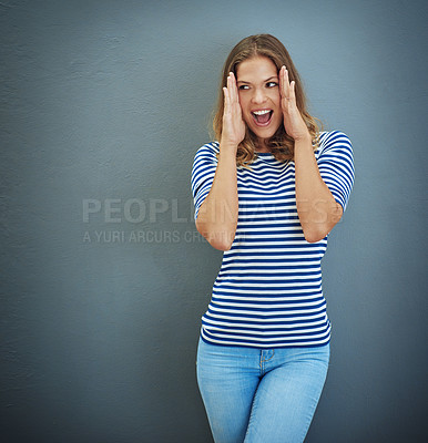 Buy stock photo Studio shot of a young woman looking amazed against a gray background