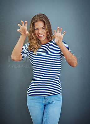 Buy stock photo Studio shot of a young woman making a growling gesture against a gray background