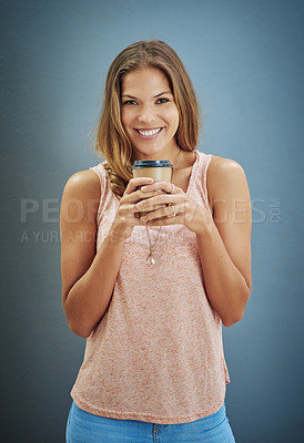 Buy stock photo Studio portrait of a young woman drinking a cup of coffee against a gray background